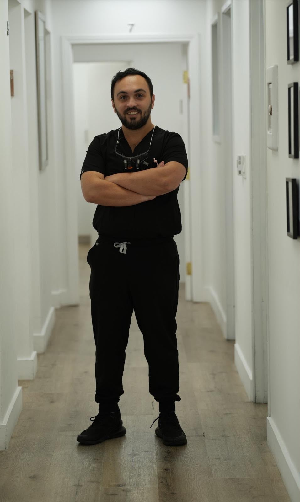 Portrait of Joshua Aminpour in a dental-office hallway